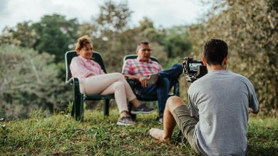 Casal de turistas sendo entrevistado ao ar livre em um jardim.