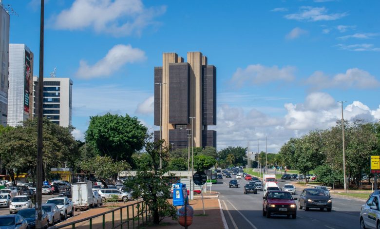 Vista externa do Banco Central do Brasil em Brasília, sob um céu colorido.